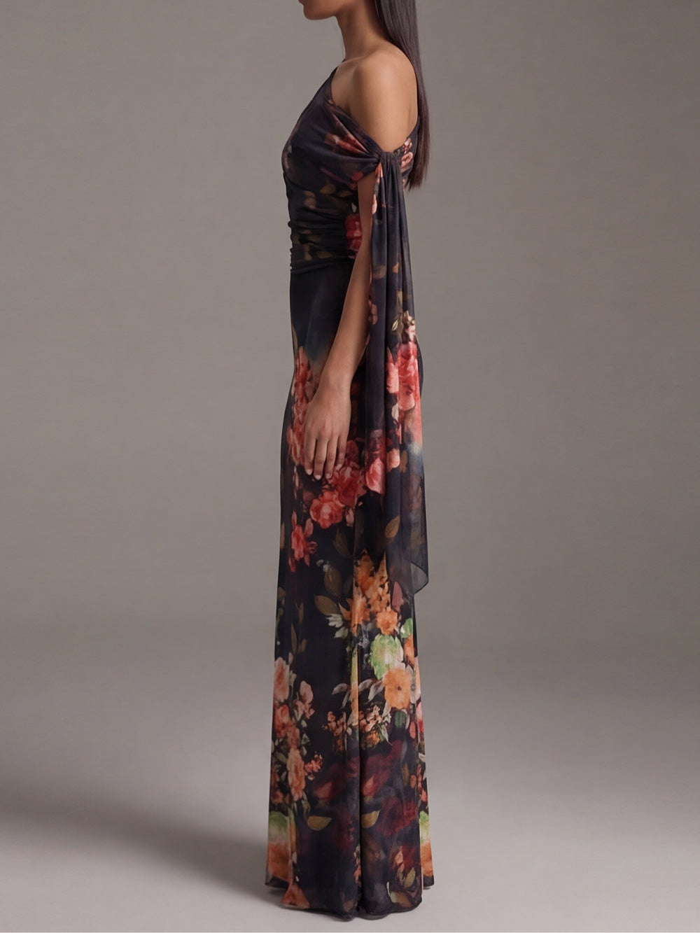 Maxivestido negro de gasa plisada, con un hombro descubierto y estampado