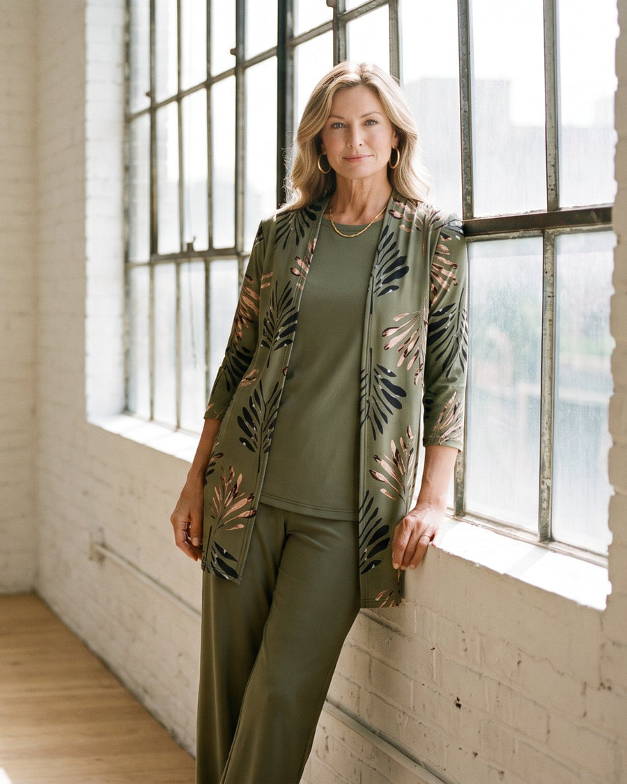 Woman in an olive three-piece set by a loft window